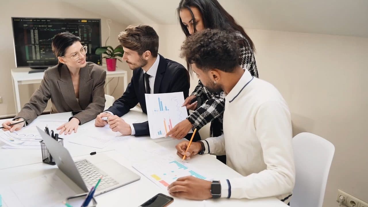 Consultants reviewing printed charts around a meeting table
