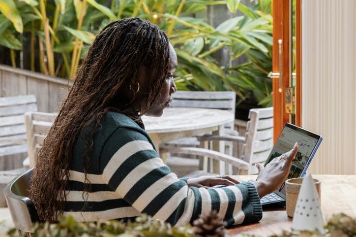 A woman working on a tablet at a café table
