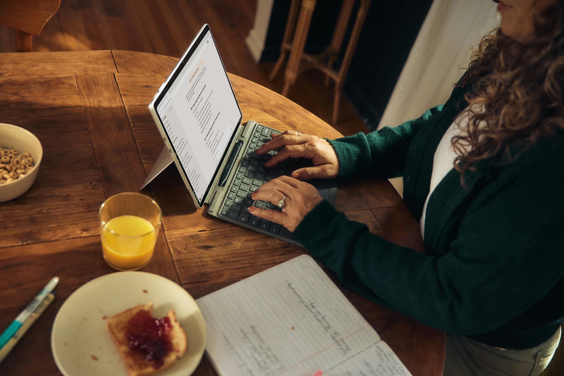 A consultant typing on a laptop at a wooden table