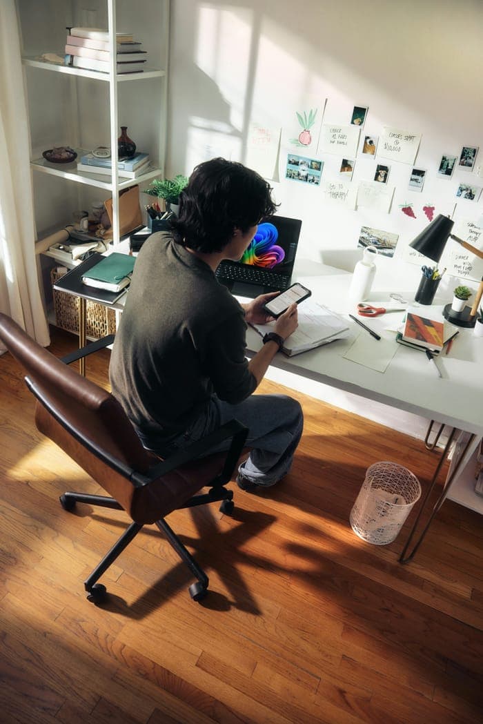 A woman working at a desk with her phone